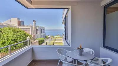 a balcony with a table and chairs and a view of the ocean at Le Paradis 5 in Hermanus