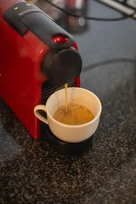 a coffee maker is pouring coffee into a cup at Two Horizons Apartment 6 in Hermanus