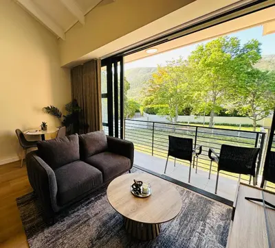 a living room with a couch and a table at Two Horizons Apartment 6 in Hermanus