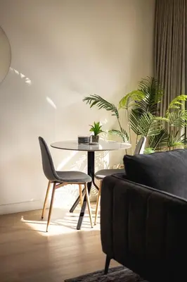 a table and chairs in a room with plants at Two Horizons Apartment 6 in Hermanus