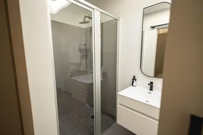 a bathroom with a glass shower and a sink at Two Horizons Apartment 6 in Hermanus