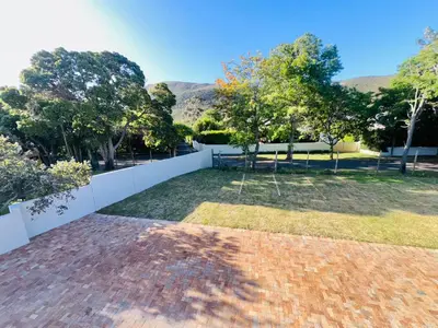 a view of a garden with trees and a fence at Two Horizons Apartment 6 in Hermanus