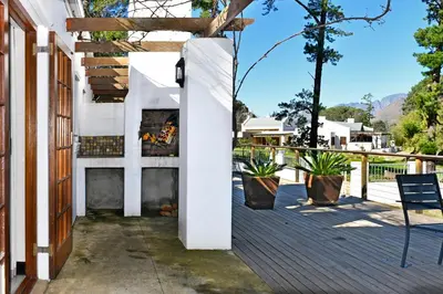 a fireplace on the deck of a house at Topiary Wine Estate & Cottages in Franschhoek