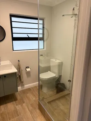 a bathroom with a toilet and a glass shower at Suburban Bliss in Stellenbosch
