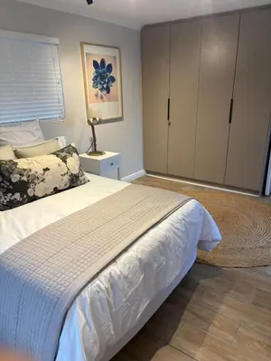 a bedroom with a large bed and a dresser at Suburban Bliss in Stellenbosch