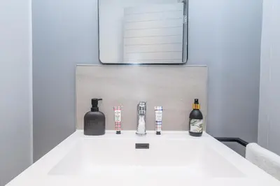 a white counter top with bottles and a mirror at Riverlands - Lux 1 bedroom Apartment with Parking in Cape Town