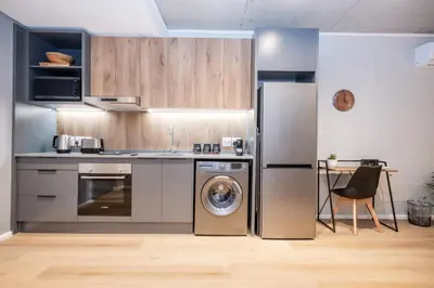 a kitchen with a stainless steel refrigerator and a dishwasher at Riverlands - Lux 1 bedroom Apartment with Parking in Cape Town