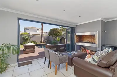 a living room with a couch and a fireplace at Ocean Whisper Terrace Villa in Cape Town
