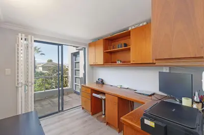an office with a desk with a computer and a balcony at Ocean Whisper Terrace Villa in Cape Town