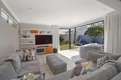 a living room with two couches and a flat screen tv at Ocean Whisper Terrace Villa in Cape Town