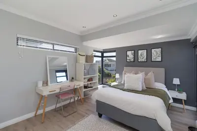 a bedroom with a bed and a desk and a mirror at Ocean Whisper Terrace Villa in Cape Town