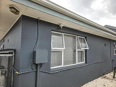 a blue house with a window and a fence at Elianta House in Cape Town