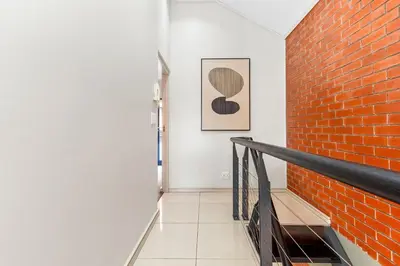a hallway with a brick wall and a staircase at Manhattan Wharfside 301 in Cape Town