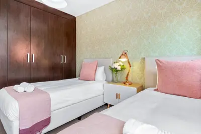 two beds in a room with pink and white at Manhattan Wharfside 301 in Cape Town