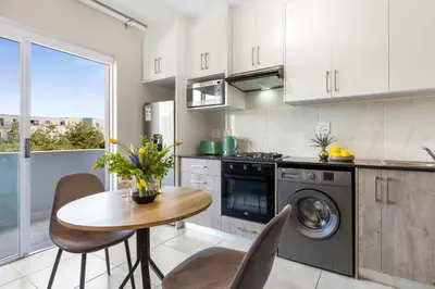a kitchen with a table and a stove and a sink at The Orion 18 in Table View