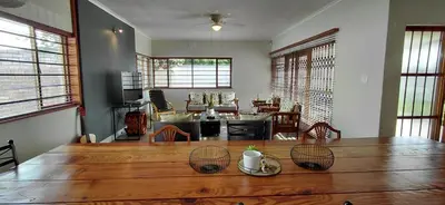 a living room with a table and a dining room at 25 on Union in Strand