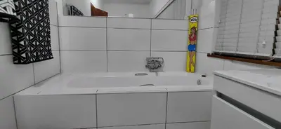 a white bathroom with a tub and a sink at 25 on Union in Strand