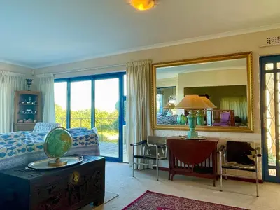 a living room with a bed and a mirror at Pitkindie Oceanfront Escape in Hermanus