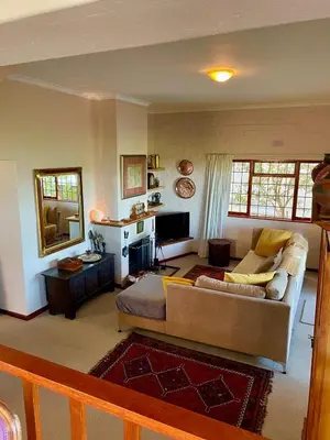 a living room with a couch and a television at Pitkindie Oceanfront Escape in Hermanus