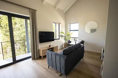 a living room with a couch and a television at Heaven & Earth Apartment 8 in Hermanus
