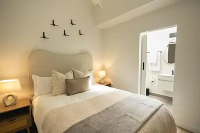 a bedroom with a large bed with two lights on it at Heaven & Earth Apartment 8 in Hermanus