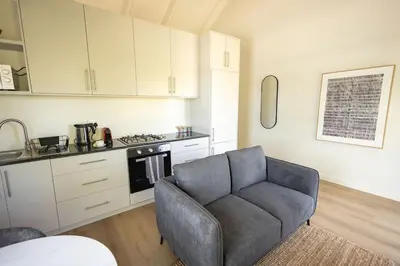 a living room with a couch and a kitchen at Heaven & Earth Apartment 8 in Hermanus