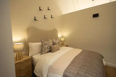 a bedroom with a large bed with two lamps on it at Valley's Embrace Apartment 7 in Hermanus