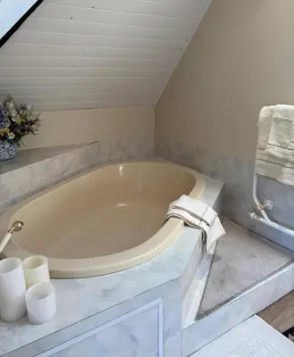 a bathroom with a large tub with towels on it at Shire Lodge in Cape Town