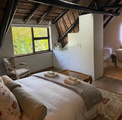 a bedroom with a large bed with two towels on it at Shire Lodge in Cape Town