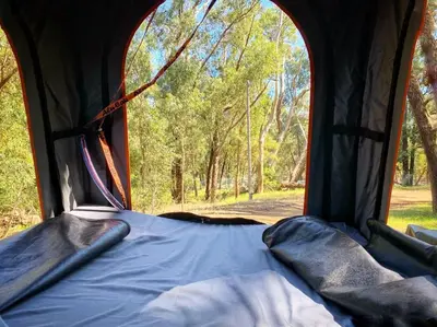a bed in a tent with an open window at Happy Campers South Africa in Strand