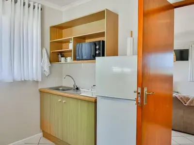 a kitchen with a white refrigerator and a sink at Whales & Wonders Guesthouse in Hermanus
