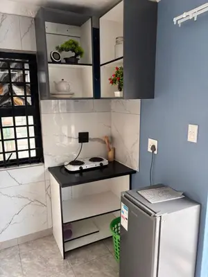 a small kitchen with a stove and a refrigerator at Browns villa and construction pty ltd in Cape Town