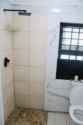 a bathroom with a toilet and a window at Browns villa and construction pty ltd in Cape Town