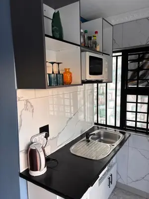 a small kitchen with a sink and a microwave at Browns villa and construction pty ltd in Cape Town
