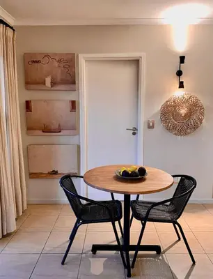 a dining room with a table and two chairs at Treetops Studio in Cape Town