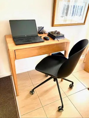 a laptop computer sitting on a wooden desk with a chair at Treetops Studio in Cape Town