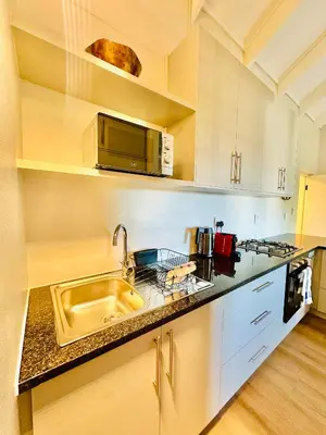 a kitchen with a sink and a microwave at Aurora Valley Escape Apartment 9 in Hermanus