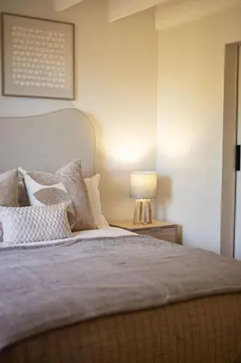 a bedroom with a bed with a lamp on a table at Aurora Valley Escape Apartment 9 in Hermanus