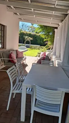 a white table and chairs on a patio at La Mode Garden Cottage in Paarl