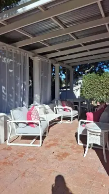 a group of white chairs sitting on a patio at La Mode Garden Cottage in Paarl