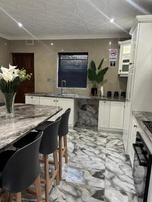 a kitchen with a marble floor and a counter top at Luxurious Family Home 2