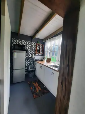 a small kitchen with a sink and a refrigerator at Stone Cottage in Grabouw