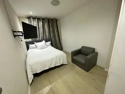 a bedroom with a bed and a chair at Joy House in Cape Town