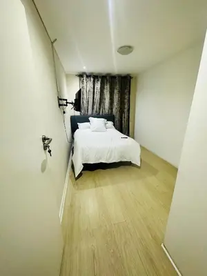 a bedroom with a white bed and a window at Joy House in Cape Town