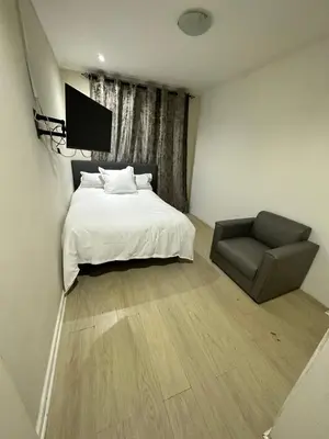 a bedroom with a bed and a chair at Joy House in Cape Town