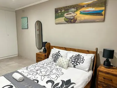 a bedroom with a bed and a painting on the wall at Blade Flatlet 2 in Silver Sands