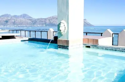 a swimming pool with a clock in the water at The Strand Pavilion Gordon's Bay in Strand