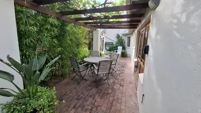 a patio with a table and chairs on a brick patio at The Cottage, Heide Avenue in Somerset West