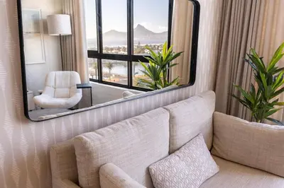 a living room with a couch and a large mirror at Modern 1 Bedroom Table Mountain View Hideaway, Milnerton in Cape Town