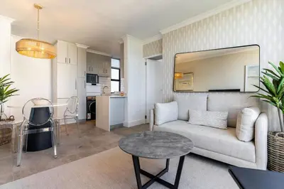 a living room with a couch and a table at Modern 1 Bedroom Table Mountain View Hideaway, Milnerton in Cape Town